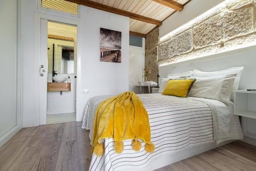 sypialnia z łóżkiem z żółtym kocem w obiekcie Apartamento Almuiña w mieście Marín