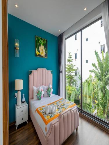 a bedroom with a pink bed and a large window at Chuỗi Villa 12 Ngủ - Trung Tâm Bãi Cháy in Ha Long