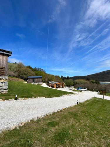 a kite is flying in the sky over a field at Cabañas O Recuncho do Sor in O Barqueiro