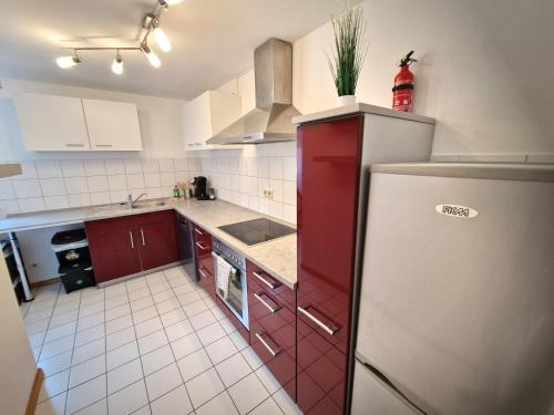 una cucina con armadi rossi e frigorifero di Zauberhaft übernachten - nur ~7 min. vom Europa-Park a Ettenheim