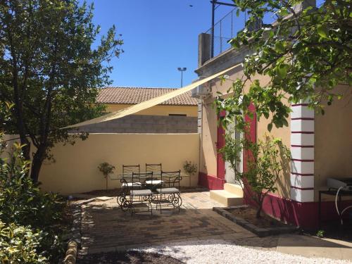 een patio met een tafel en stoelen voor een gebouw bij Romantic Tiny House with private terrace and shared pool in Bessan