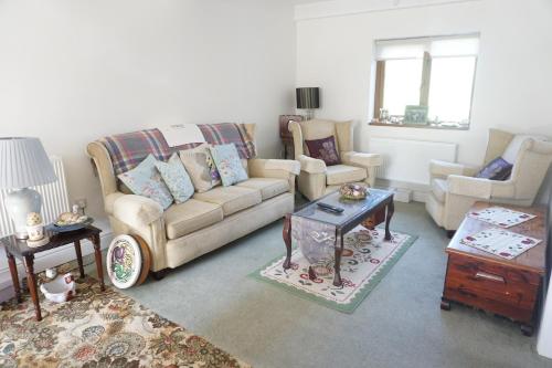 Holywell Lodge : غرفة معيشة مع أريكة وكرسيين