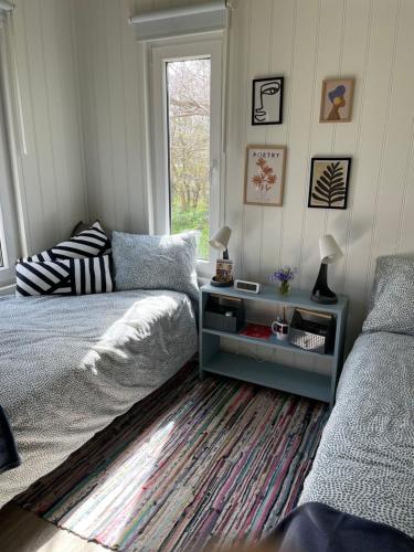 a bedroom with a bed and a table and a window at Tiny house Lund in Lund