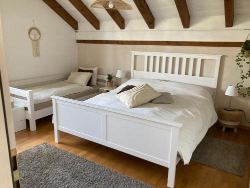 a bedroom with a large white bed and a bench at Escale sur la Côte in Porrentruy