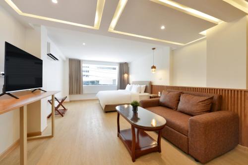 a living room with a couch and a bed at Ratchathewi Hyde Away in Pratunam
