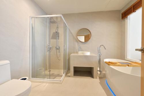 a bathroom with a shower and a sink at Ratchathewi Hyde Away in Pratunam