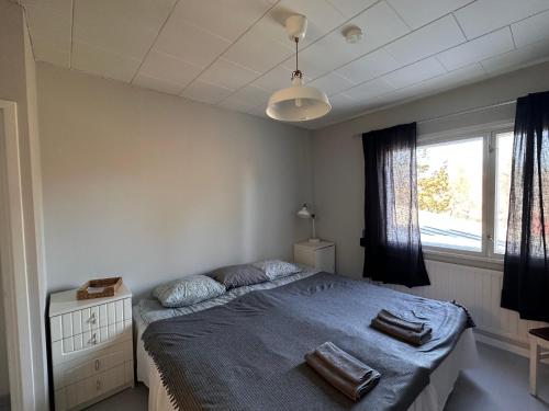 a bedroom with a bed with blue sheets and a window at Enonkosken Kartano & Guesthouse in Enonkoski
