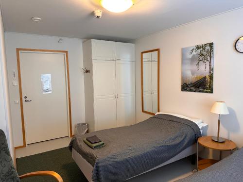 a bedroom with a bed and a clock on the wall at Enonkosken Kartano & Guesthouse in Enonkoski