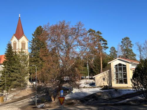 a church with a steeple and a street sign in front at Enonkosken Kartano & Guesthouse in Enonkoski