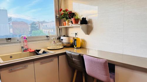 eine Küche mit einer Theke mit einem Waschbecken und einem Fenster in der Unterkunft Sweet home near Paris with Eiffel Tower view & 1 cozy private room or entire apartment with 3 rooms in Courbevoie