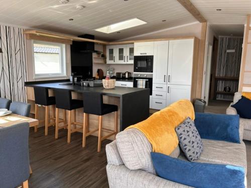 a kitchen and living room with a couch and a table at Bull Rush Retreats luxury hot tub lodge at Tattershall Lakes in Tattershall