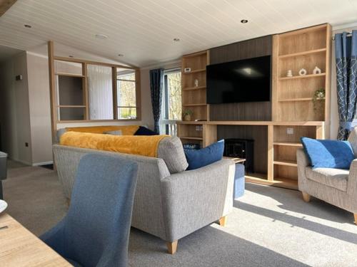 a living room with a couch and a tv at Bull Rush Retreats luxury hot tub lodge at Tattershall Lakes in Tattershall
