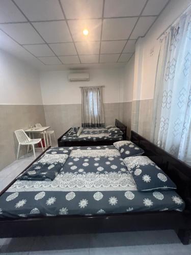 1 Schlafzimmer mit 2 Betten und einem Tisch mit einem Stuhl in der Unterkunft Như Ý in Đà Nẵng