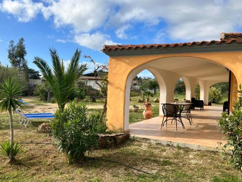 a pavilion with a table and chairs in a yard at Villa Grecale in Cala Liberotto