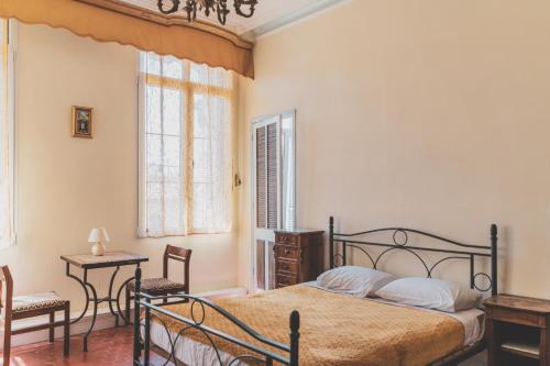 - une chambre avec un lit, une table et des chaises dans l'établissement Maison Pelissier - Chambres d’hôtes avec piscine, à Cuxac-dʼAude