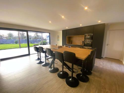 une cuisine avec une grande table et des chaises en bois dans l'établissement Fouesnant, superbe maison en bois, proche de la plage de Mousterlin, à Fouesnant