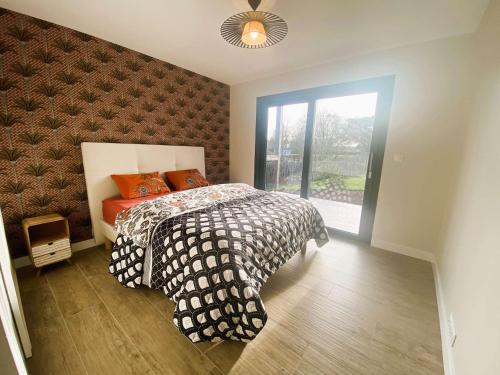 une chambre avec un lit et une grande fenêtre dans l'établissement Fouesnant, superbe maison en bois, proche de la plage de Mousterlin, à Fouesnant