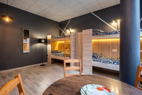 Cette chambre comprend 2 lits superposés et une table. dans l'établissement Keja Rooms II - Pokoje Noclegi w Centrum Gdyni, à Gdynia
