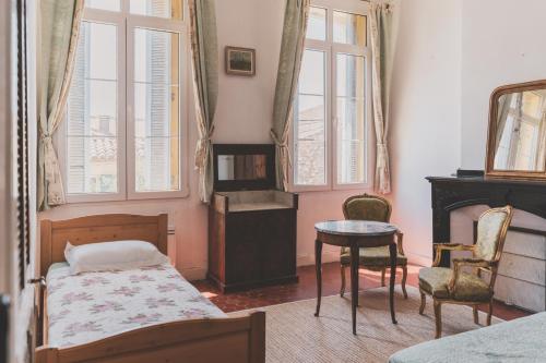 Schlafzimmer mit einem Bett, einem Tisch und Stühlen in der Unterkunft Maison Pelissier - Chambres d’hôtes avec piscine in Cuxac-dʼAude