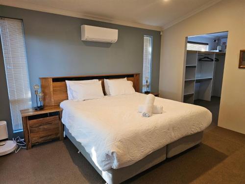 Bussell Hideaway Haven في Broadwater: غرفة نوم مع سرير مع دمية دب عليها