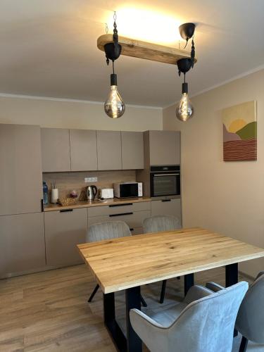 cocina y comedor con mesa de madera y sillas en Pie Jūras, en Saulkrasti