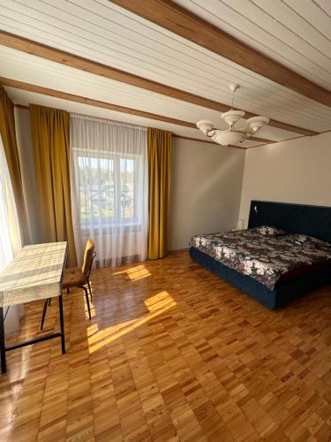 a bedroom with a bed and a chair and a ceiling at Pie Jūras in Saulkrasti