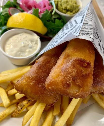 a plate of food with french fries and dip at Hotell Iföhus in Bromölla