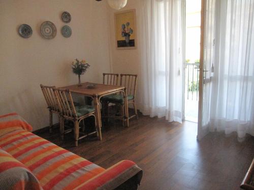 a living room with a table and chairs and a couch at Appartamento Pineta in Grado