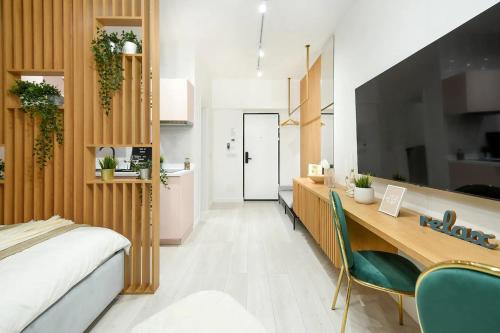 a bedroom with a desk and a bed and a kitchen at AIASTAY Bucharest River Apartments in Bucharest