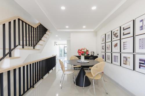 a dining room with a table and chairs and a staircase at Advanced townhouses can accommodate 14 people, with high-speed Wi Fi and parking on Netflix in Ban Non Yang Ngam