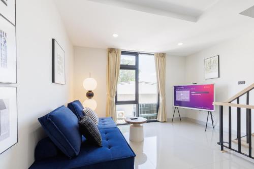 a living room with a blue couch and a tv at Advanced townhouses can accommodate 14 people, with high-speed Wi Fi and parking on Netflix in Ban Non Yang Ngam
