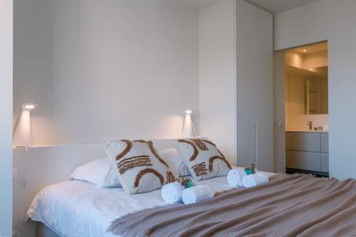 een slaapkamer met een groot bed en handdoeken bij Bright and spacious apartment with stunning views! in Knokke-Heist