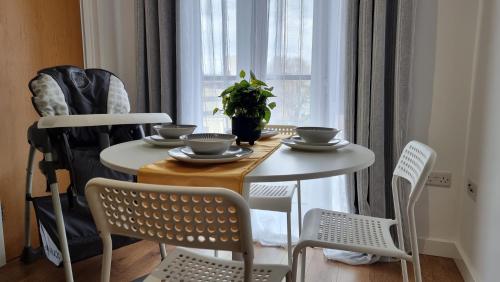 a table and chairs with bowls and plates on it at No 15 Modern Comfort in a Prime Southampton Location - Free Parking in Southampton
