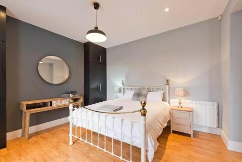 um quarto com uma cama branca e um espelho em Beautiful, large 4 bedroom city centre townhouse em Dublin