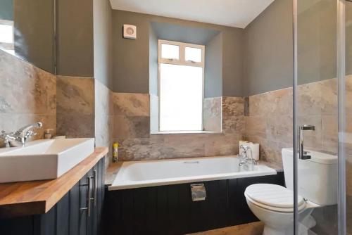 a bathroom with a tub and a toilet and a sink at Beautiful, large 4 bedroom city centre townhouse in Dublin