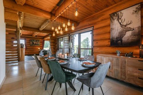 ein Esszimmer mit einem Tisch mit Stühlen und einem Hirschgemälde an der Wand in der Unterkunft Beautiful log home with stunning views in Zottegem