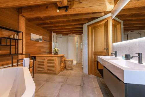 baño grande con 2 lavabos y cocina en Beautiful log home with stunning views, en Zottegem