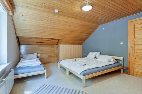 1 dormitorio con 2 camas y techo de madera en Holiday home in the greenery of Limburg en Aan de Wolfsberg