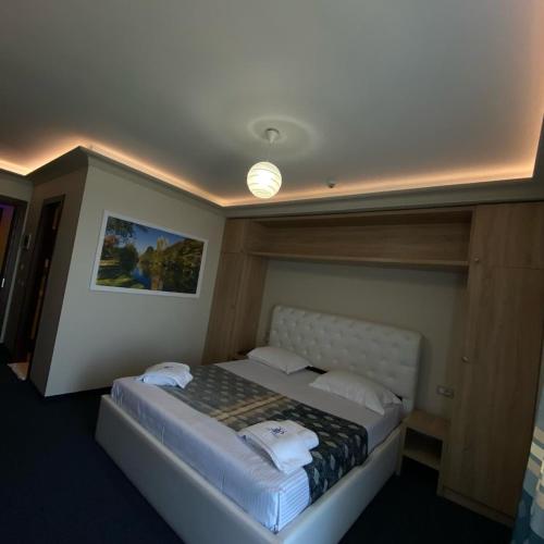 a bedroom with a bed with a light on the ceiling at Hotel Pogradeci 2 in Pogradec