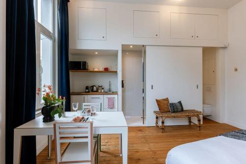 cocina y sala de estar con mesa blanca y sillas en 'The Jungle' Studio in the heart of Ghent en Gante