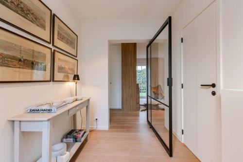 a hallway with a desk and a mirror at Beautifully decorated villa near the city of Knokke in Knokke-Heist
