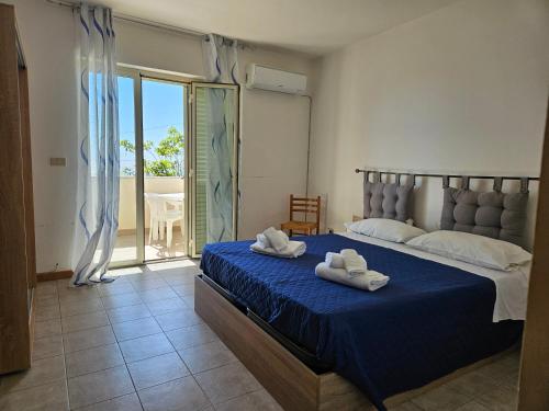 een slaapkamer met een bed met twee handdoeken erop bij FAMILY HOUSE Letojanni Taormina in Letojanni