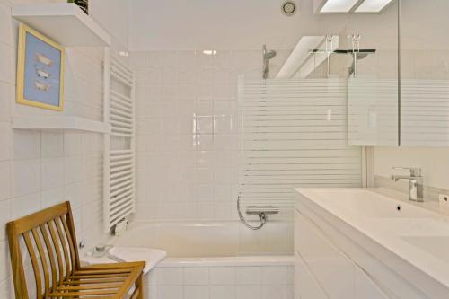 een witte badkamer met een bad en een wastafel bij Sunny and comfortable 2 bedroom appartement with stunning Sea-view and 2 terraces in Knokke-Heist