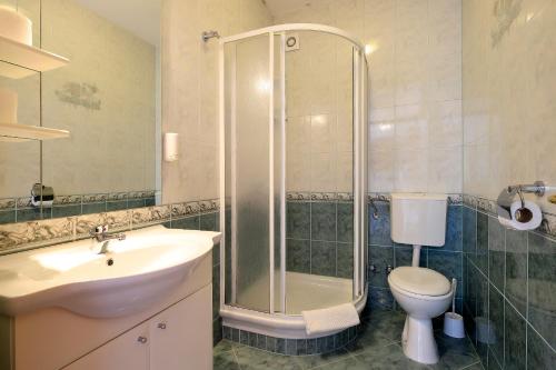 a bathroom with a shower and a sink and a toilet at Resort Trcol in Novalja