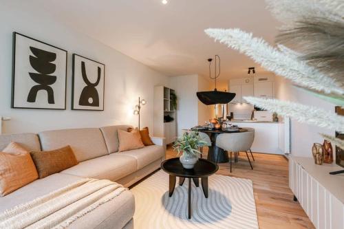 a living room with a couch and a table at Modern apartment close to the beach with common pool in Ostend