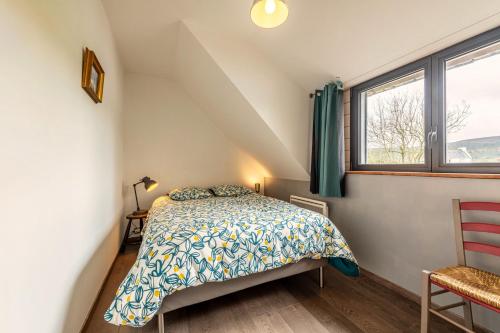 a bedroom with a bed and a window at Charme et Hâvre de Paix - Grand jardin in Trégarvan