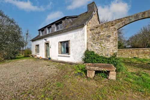 une ancienne maison en pierre avec un banc devant elle dans l'établissement Charme et Hâvre de Paix - Grand jardin, à Trégarvan