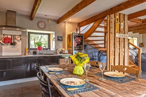 a kitchen and dining room with a wooden table and chairs at Charme et Hâvre de Paix - Grand jardin in Trégarvan