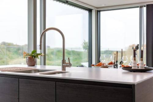 eine Küche mit einem Waschbecken und einem großen Fenster in der Unterkunft Luxurious penthouse with beautiful sea view and private parking in De Haan