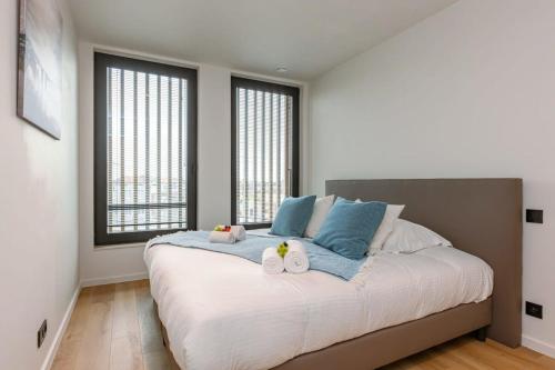 ein Schlafzimmer mit einem großen Bett mit zwei Handtüchern darauf in der Unterkunft Luxurious penthouse with beautiful sea view and private parking in De Haan